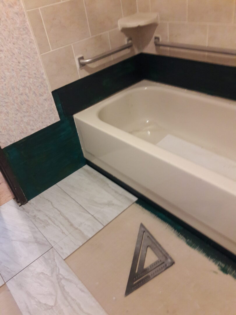 A bathroom with a tub and tile floor.