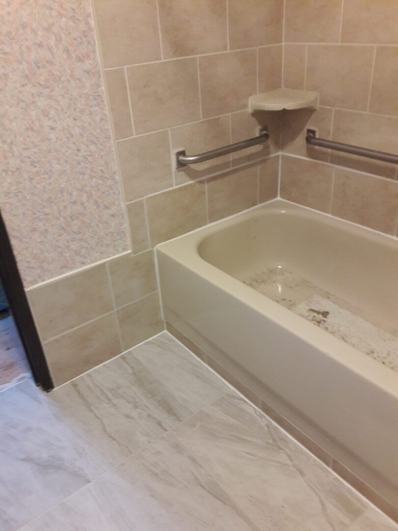 A bathroom with tile walls and floor, bathtub and shower.