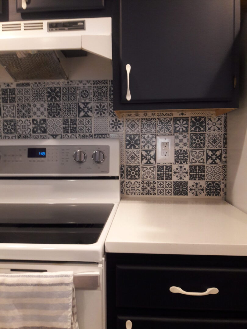 A kitchen with a stove and tile backsplash.