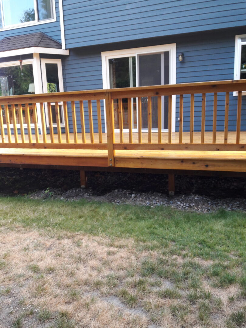 A wooden deck with a railing in the middle of it.