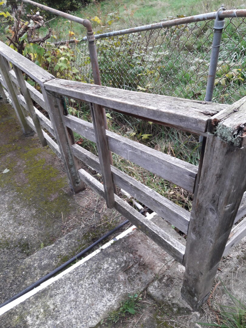 A wooden fence with metal bars on top of it.