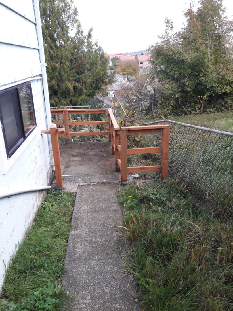 A wooden fence is going up to the side of a house.