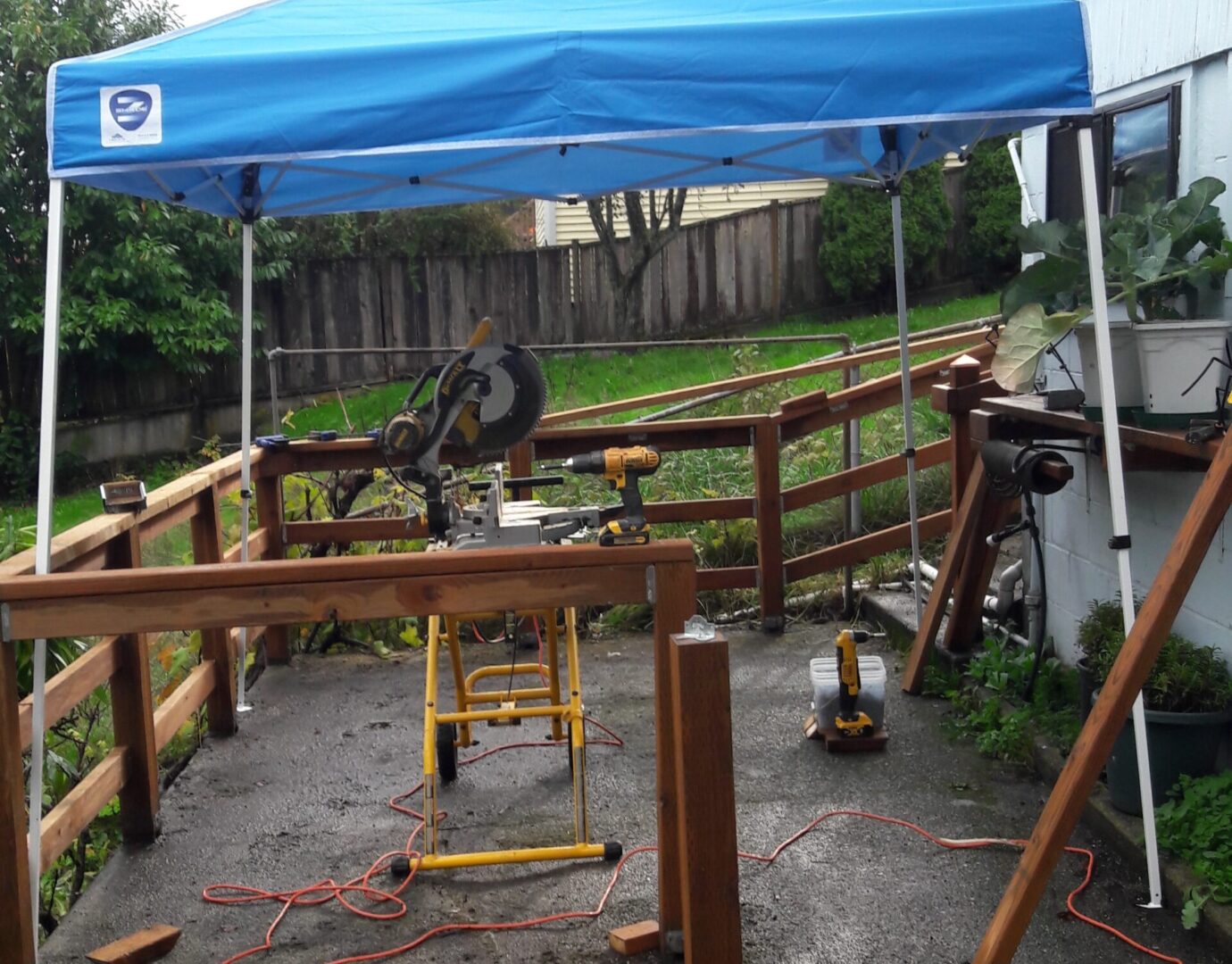 A blue canopy over the top of a wooden fence.