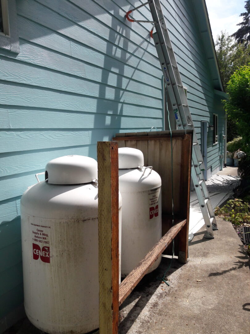 Two white tanks sitting next to a blue wall.