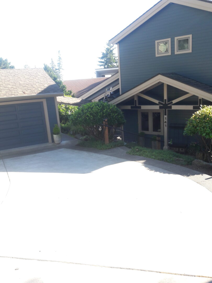 A house with a garage and driveway in front of it.