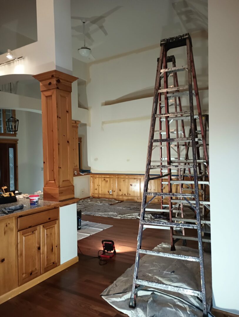 A ladder in the middle of a room with wood floors.