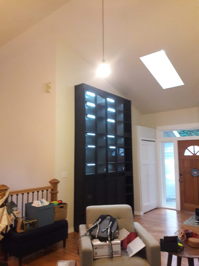 A room with a large black cabinet and a white chair