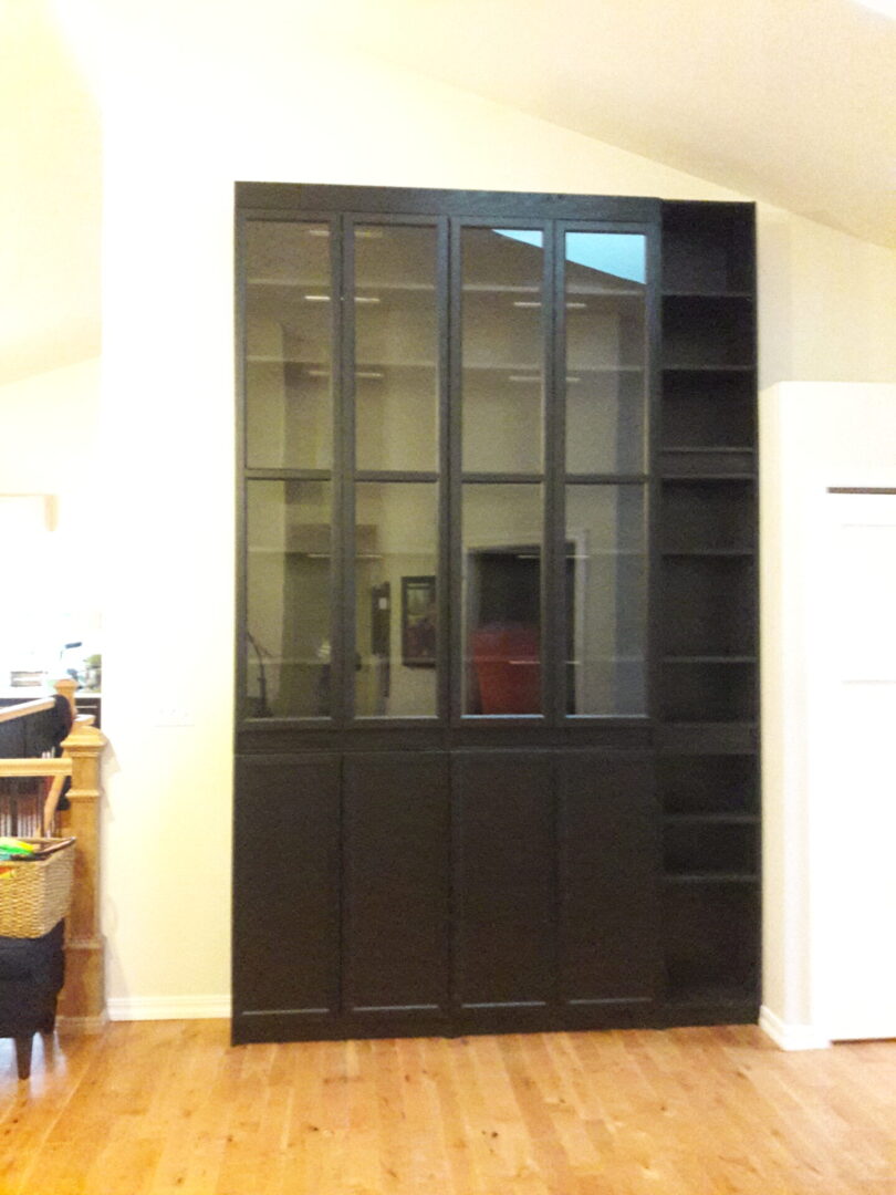 A large black bookcase with glass doors