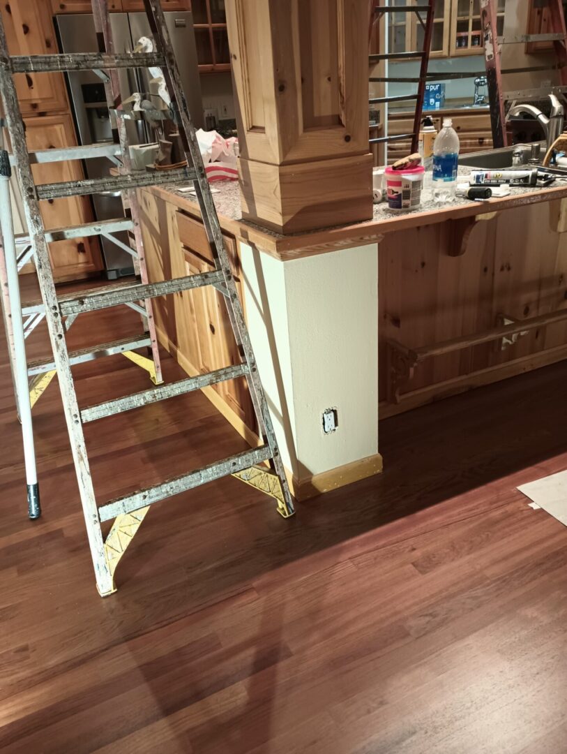 A ladder leaning up against the wall of a kitchen.