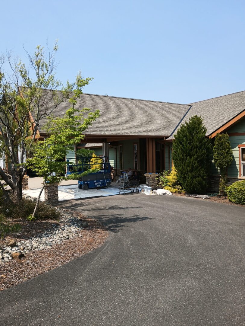 A large house with a driveway and trees.