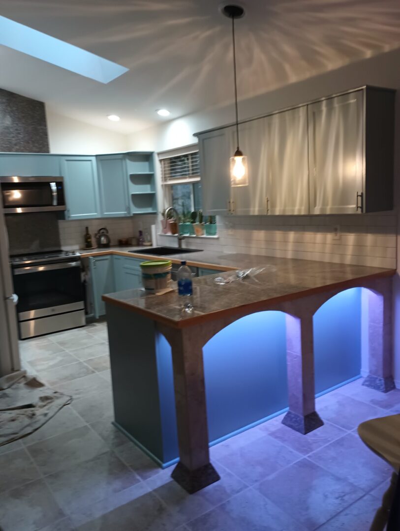 A kitchen with blue lights and an island.