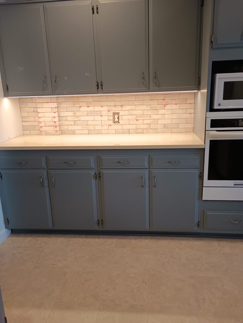 A kitchen with blue cabinets and white counters