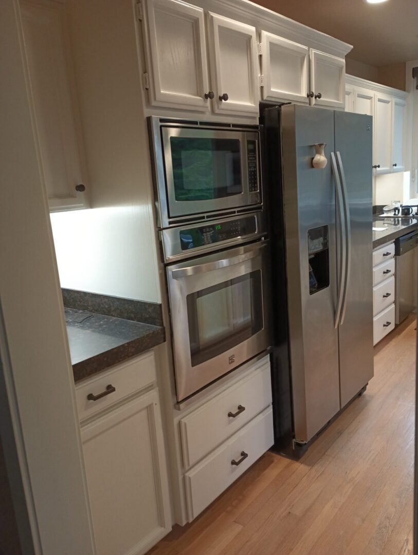 A kitchen with white cabinets and stainless steel appliances.