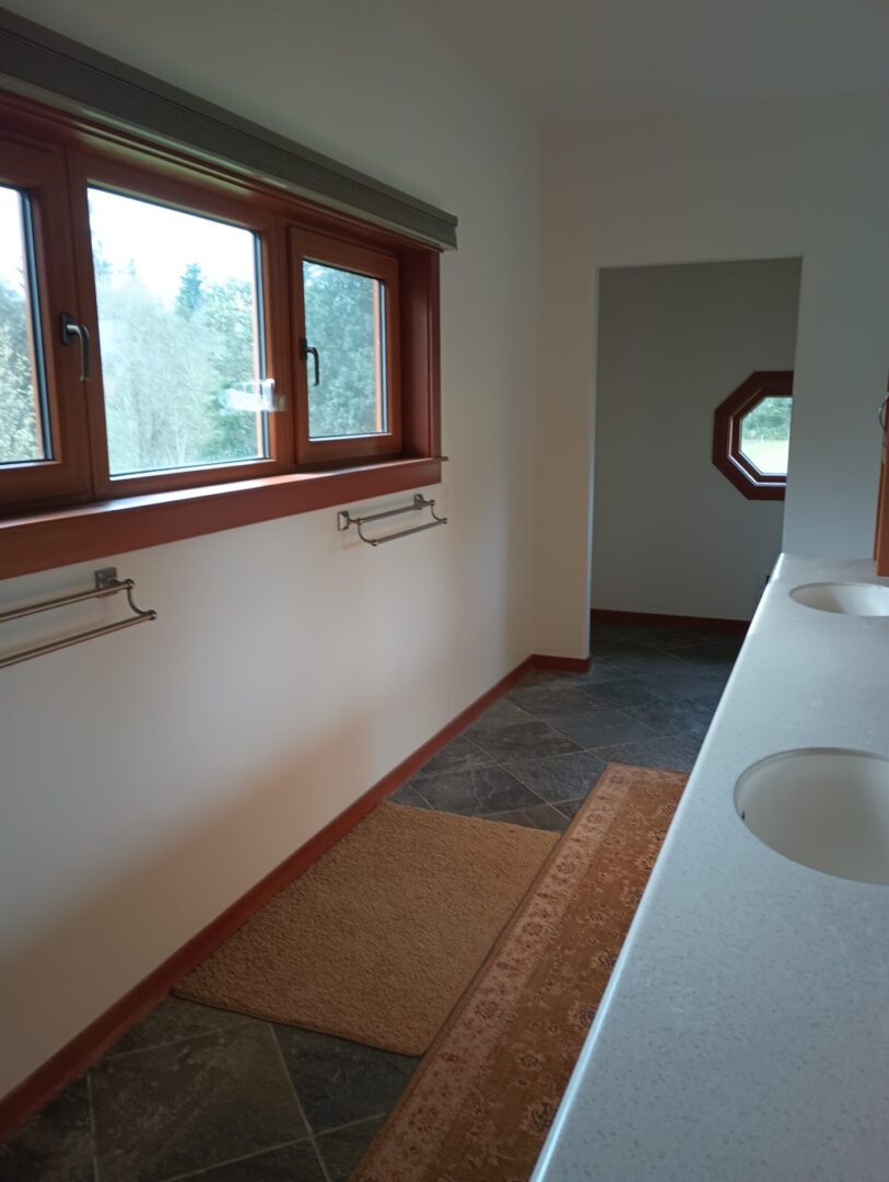 A bathroom with two sinks and a window.