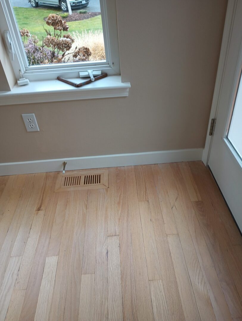 A room with hard wood floors and a window.