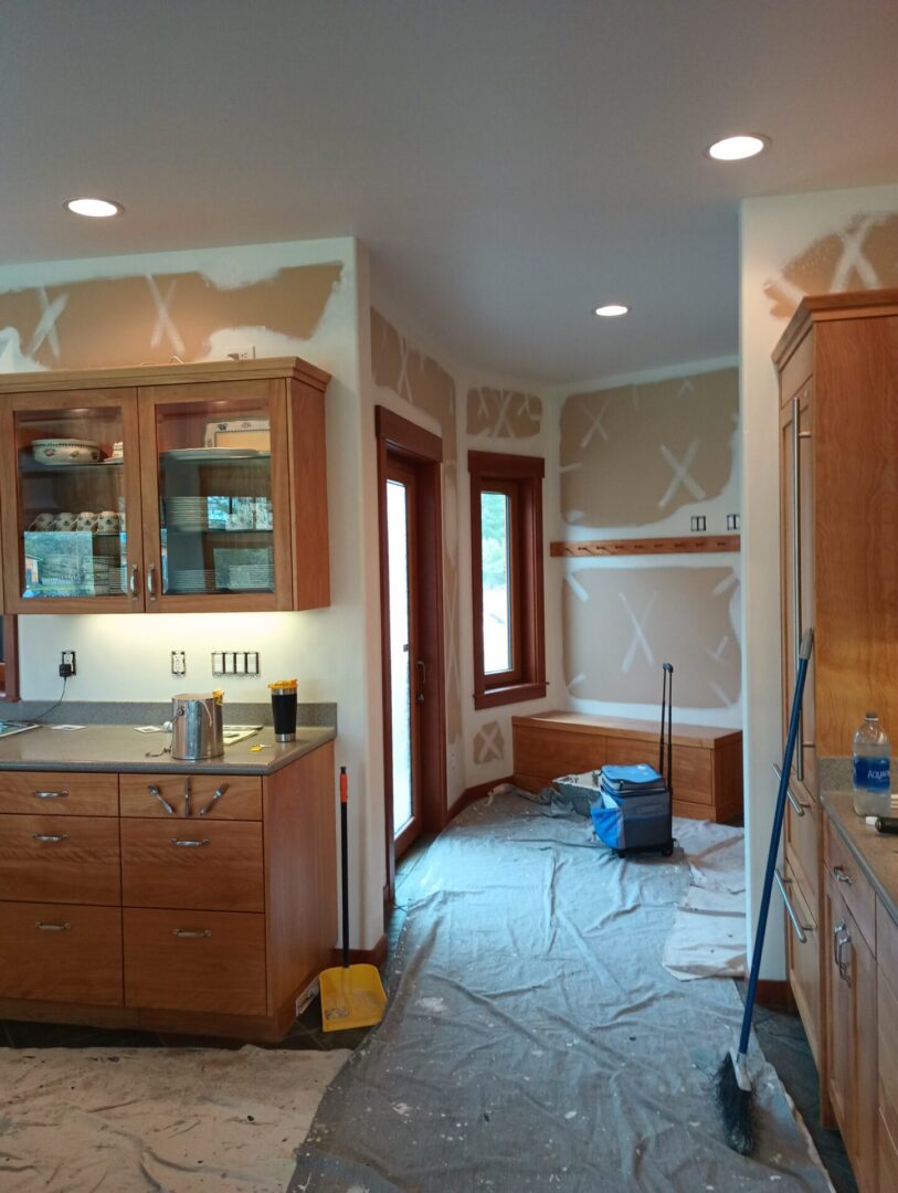 A kitchen with walls being remodeled and the cabinets are painted.